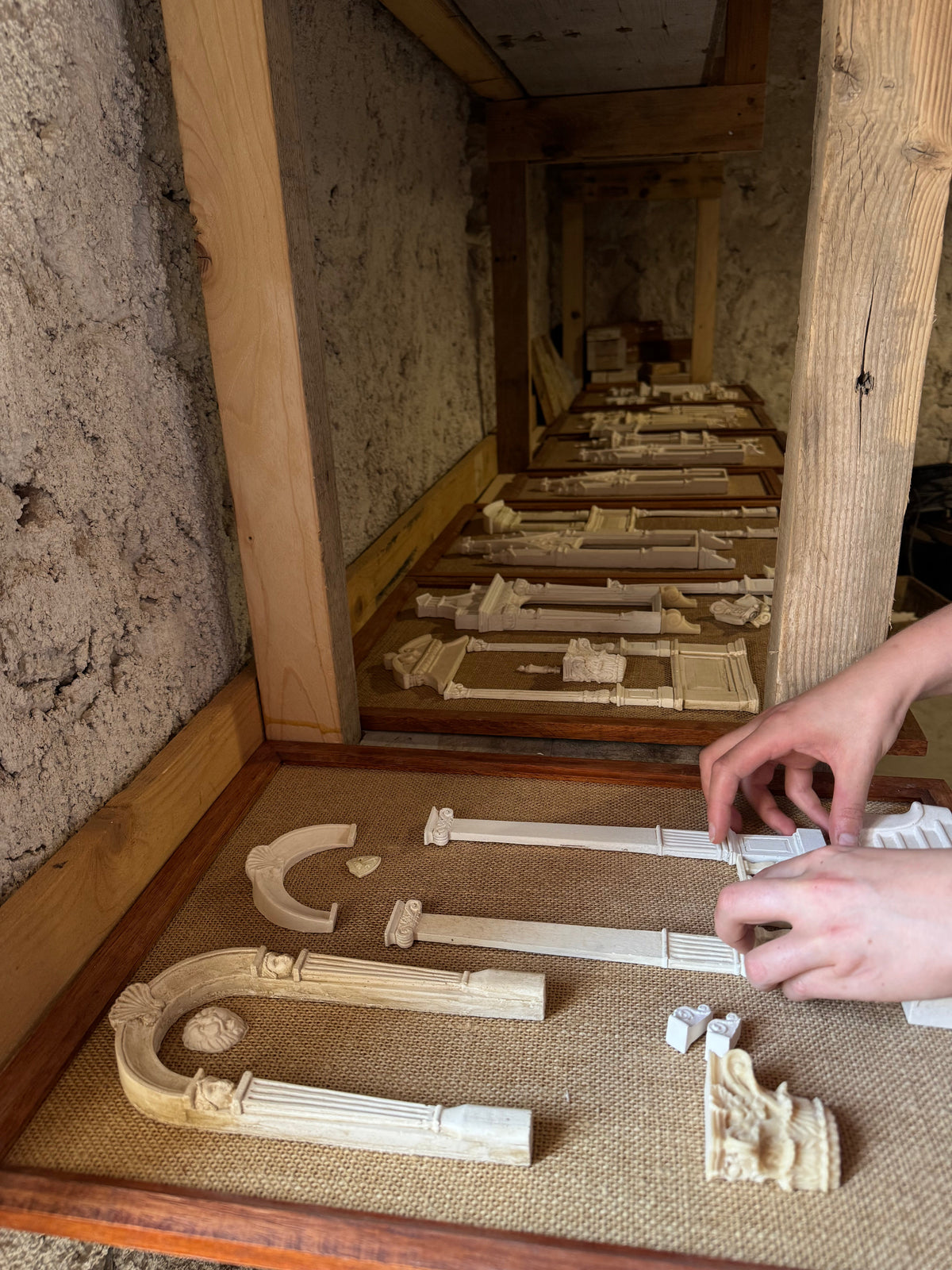 Lansdown Arts Architectural Archive panels displaying miniature classical carvings and castings arranged on woven hessian.