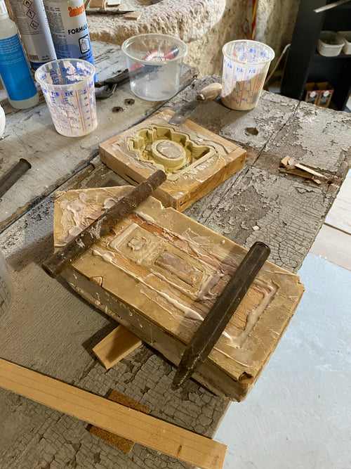 Wooden frames and miniature architectural castings arranged on a studio worktable during the making of the Architectural Archive